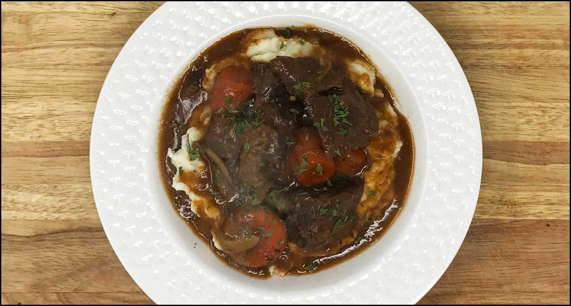 White plate of Beef Bourguignon and vegetables, a family recipe